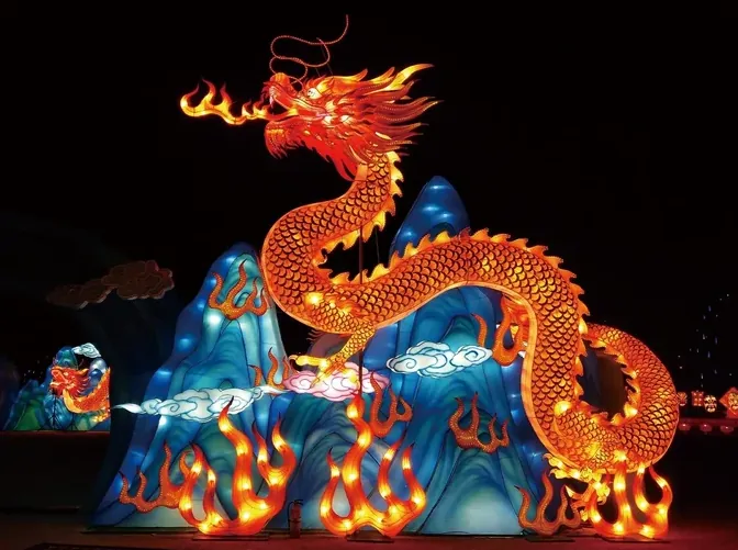 Dragón luminoso LED sobre una montaña de luz en un festival nocturno