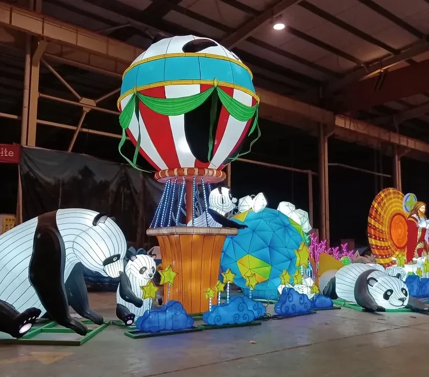 Osos panda luminosos LED junto a un globo aerostático de luz