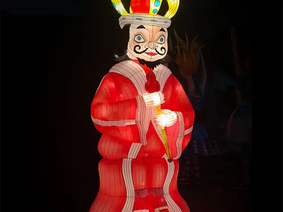Figura luminosa del rey de corazones con corona dorada con joyas, túnica roja y blanca y cetro, iluminada desde dentro