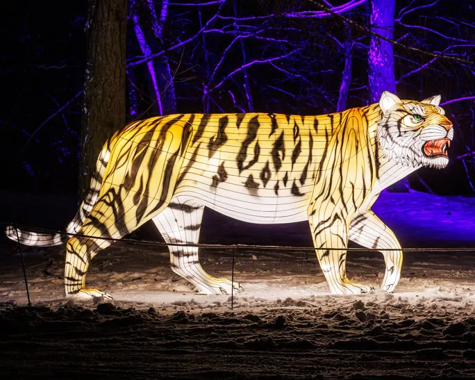 Tigre luminoso LED a escala real con las rayas resueltas en tela, iluminado de noche