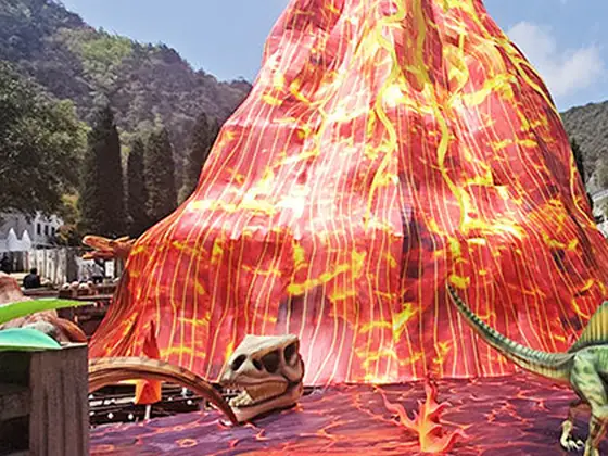 Volcán luminoso de gran formato con dinosaurios en la base
