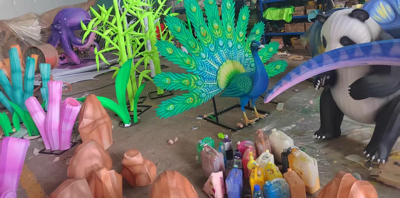 Figuras luminosas apagadas en el taller: pavo real, oso panda, pulpo, bambú y corales